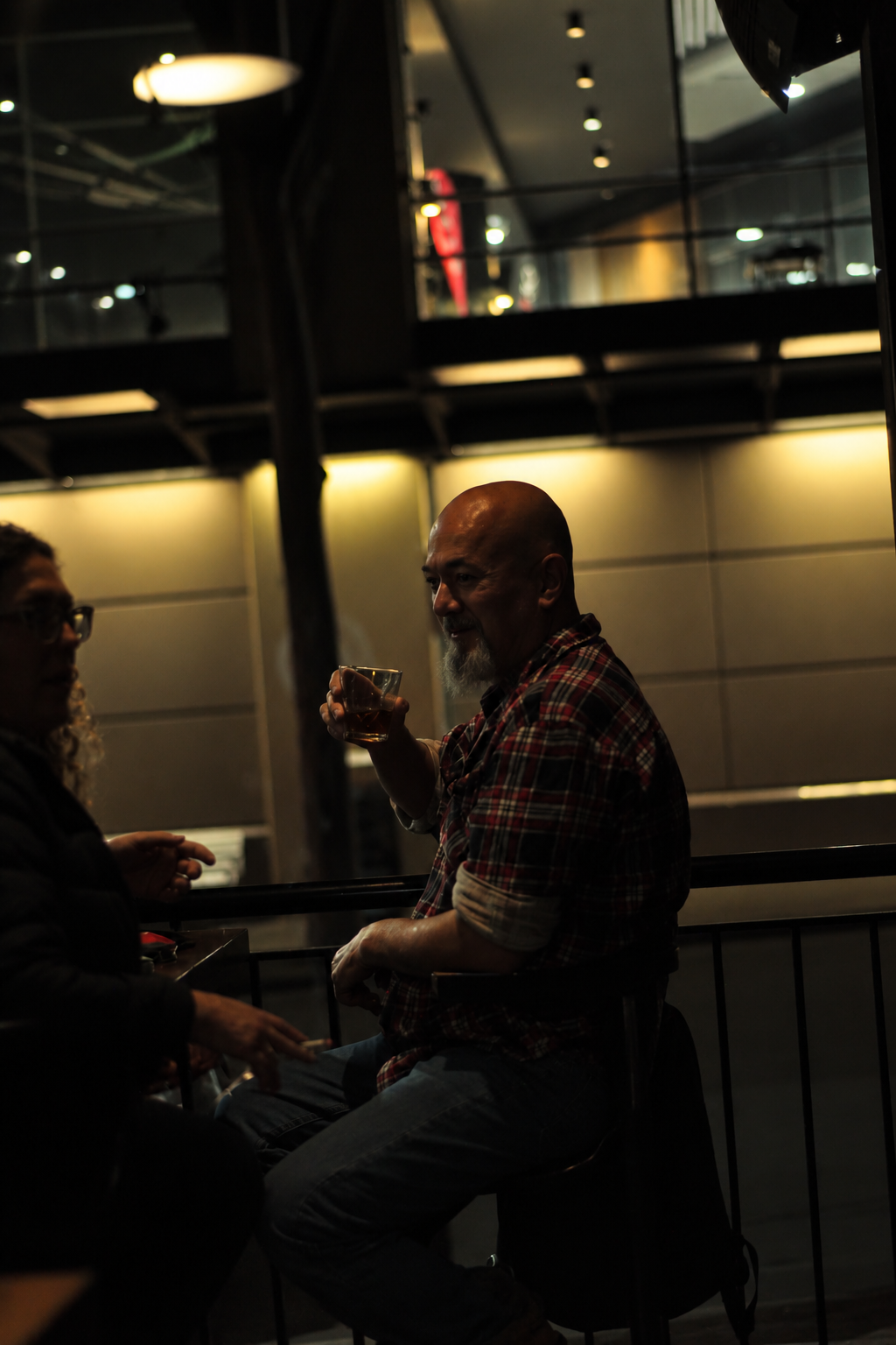 Man holding a drink in a dimly lit venue